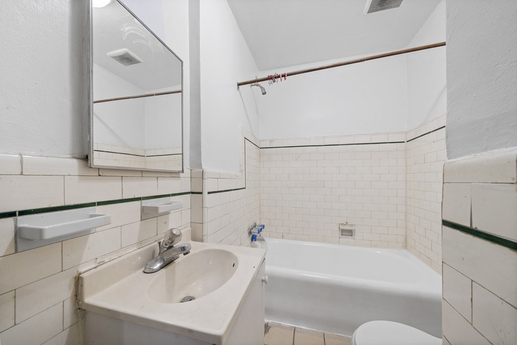 a bathroom with a sink and a bath tub and a mirror