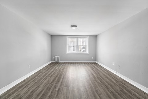A room with wooden flooring and a window.