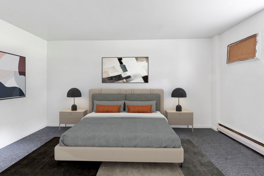 a bedroom with white walls and a gray bed with orange pillows