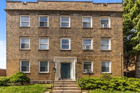 the front of a brick building with a blue door