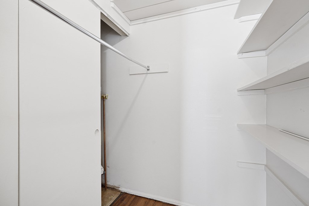 an empty room with white walls and a white closet