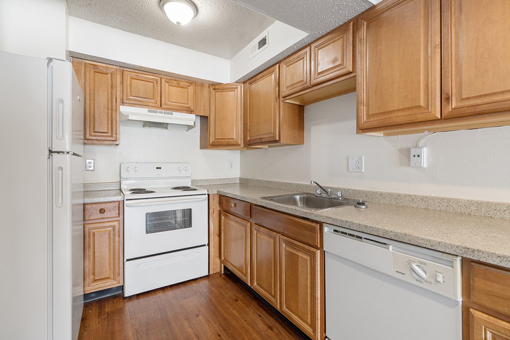 a kitchen with white appliances and wooden cabinets