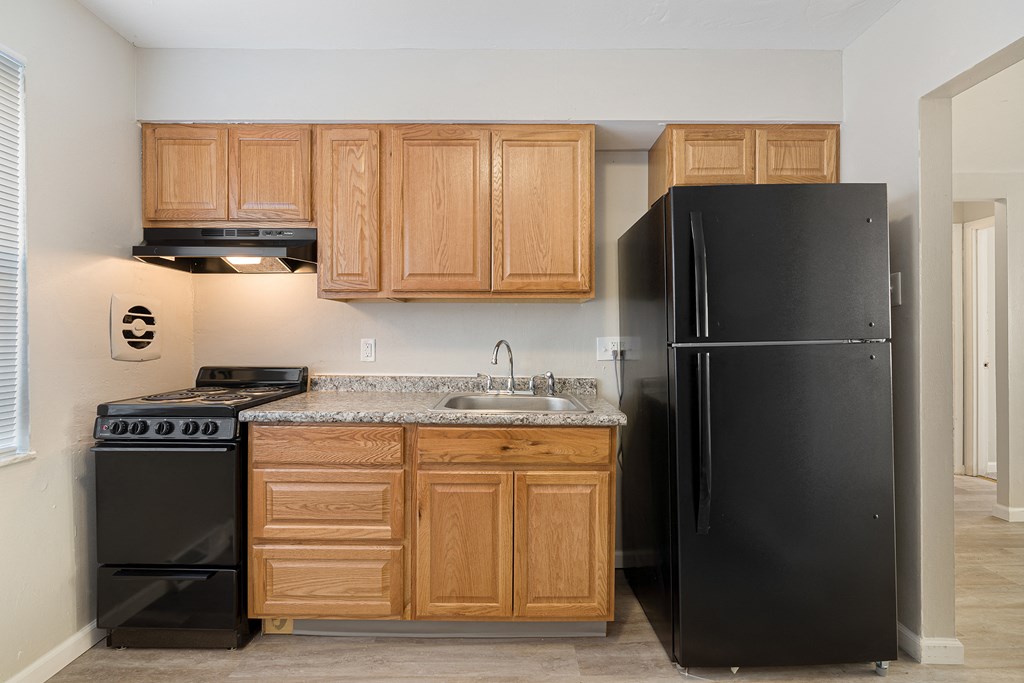 a kitchen with black appliances and wooden cabinets