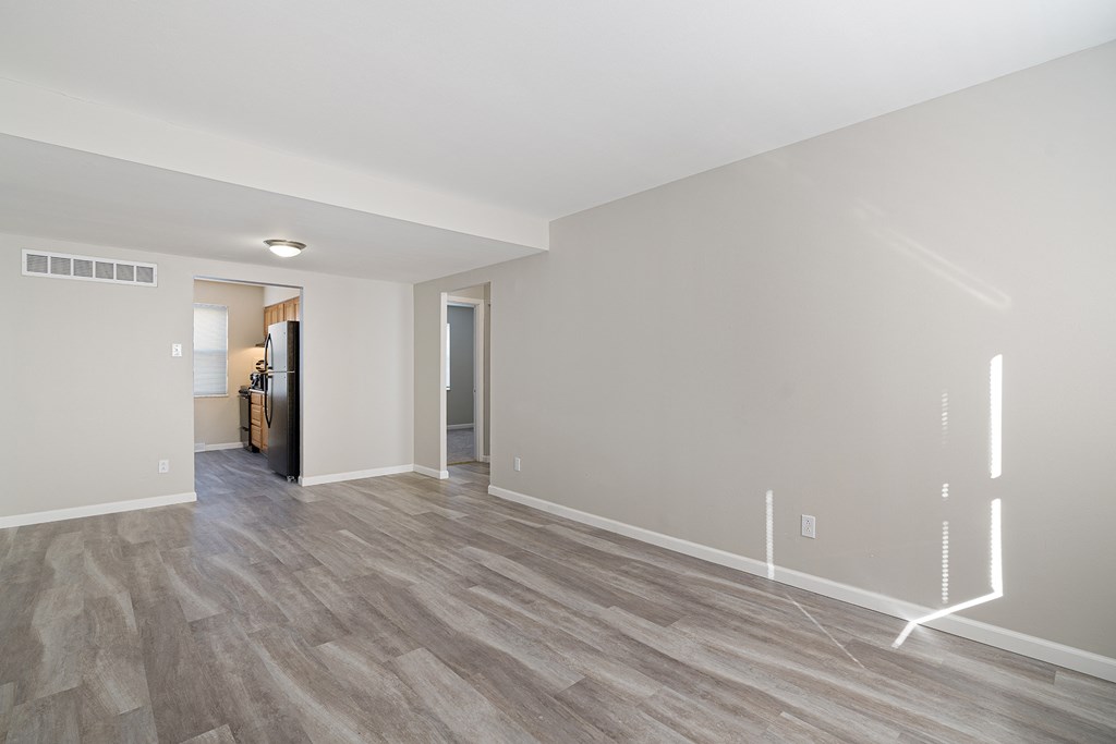a living room with a hard wood floor and white walls
