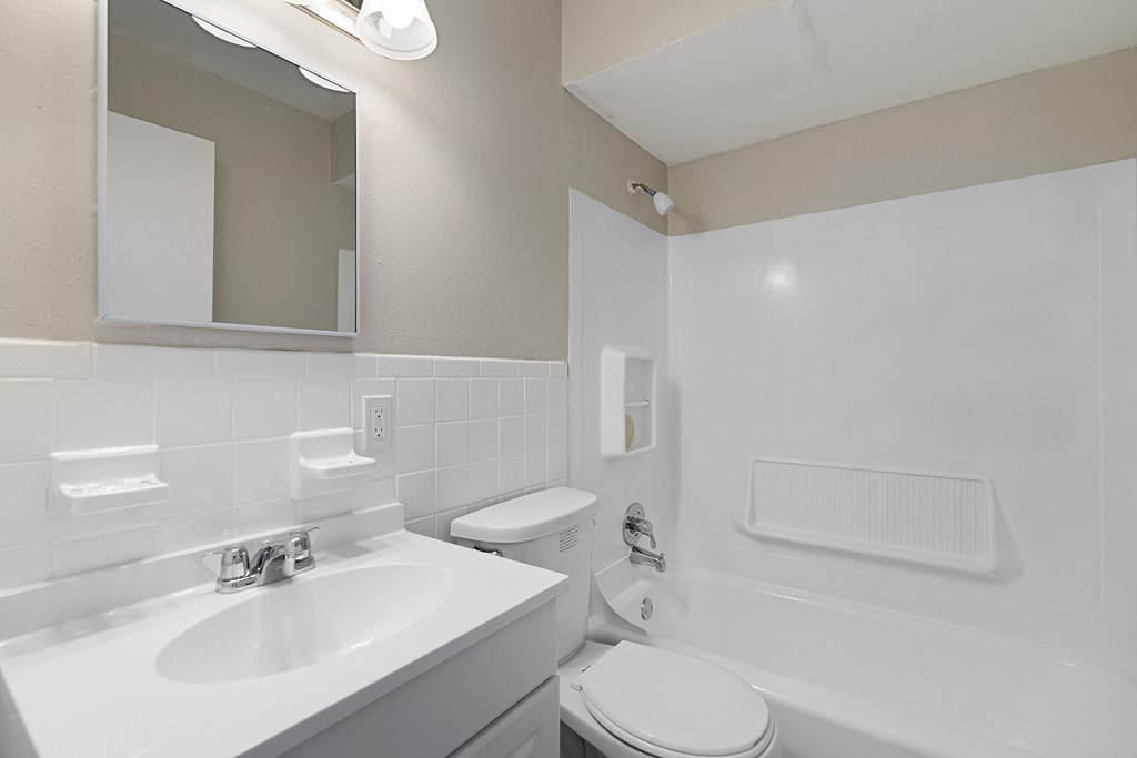 a white bathroom with a sink toilet and a mirror