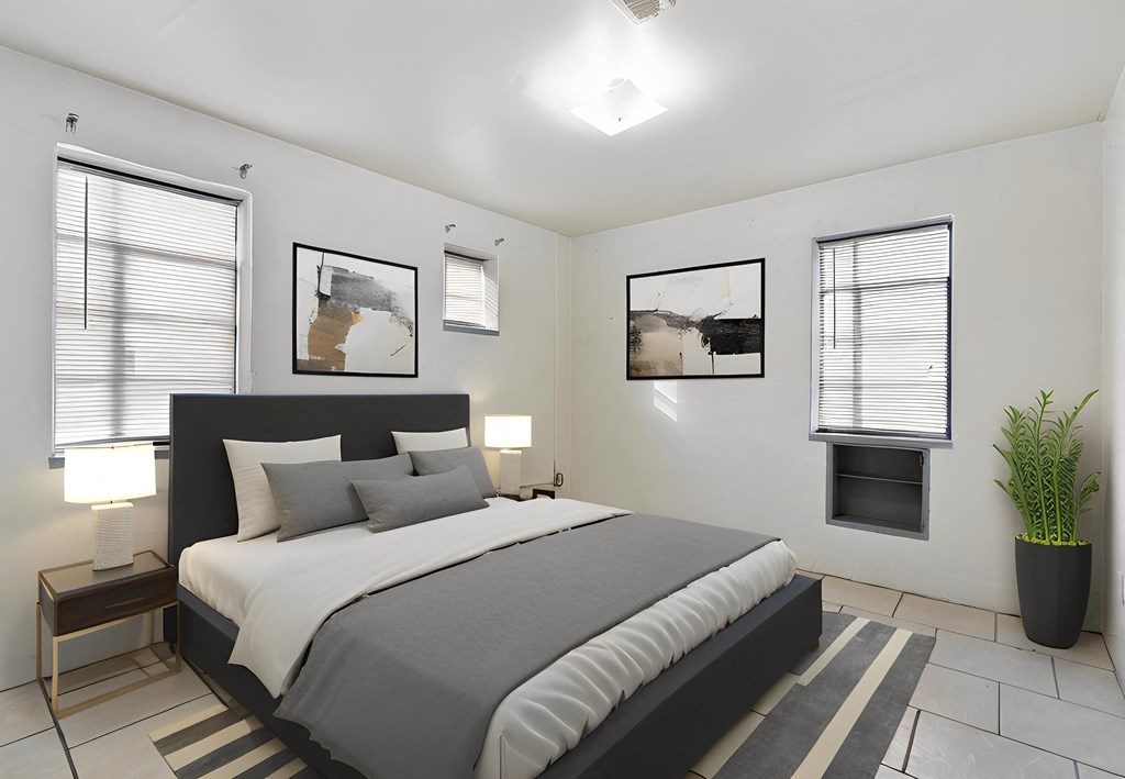 a bedroom with a bed and two windows