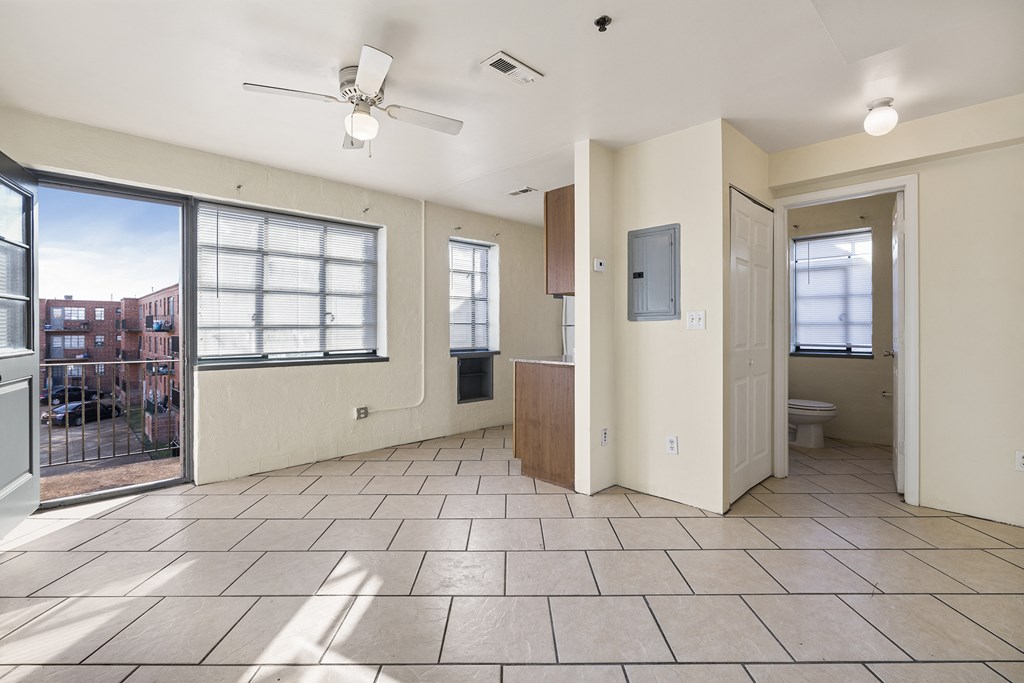 the living room has a large window and a door to the bathroom