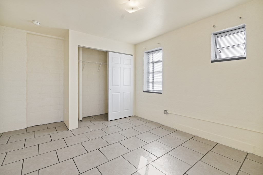 the living room has a door to the closet and a tiled floor