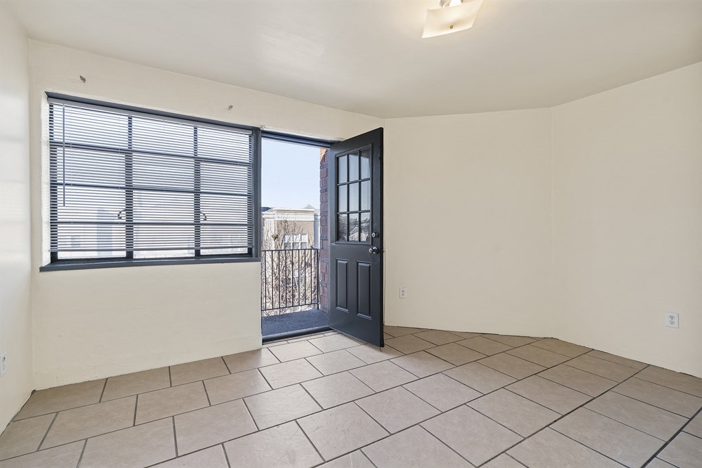 the living room has a door to the balcony and a tiled floor