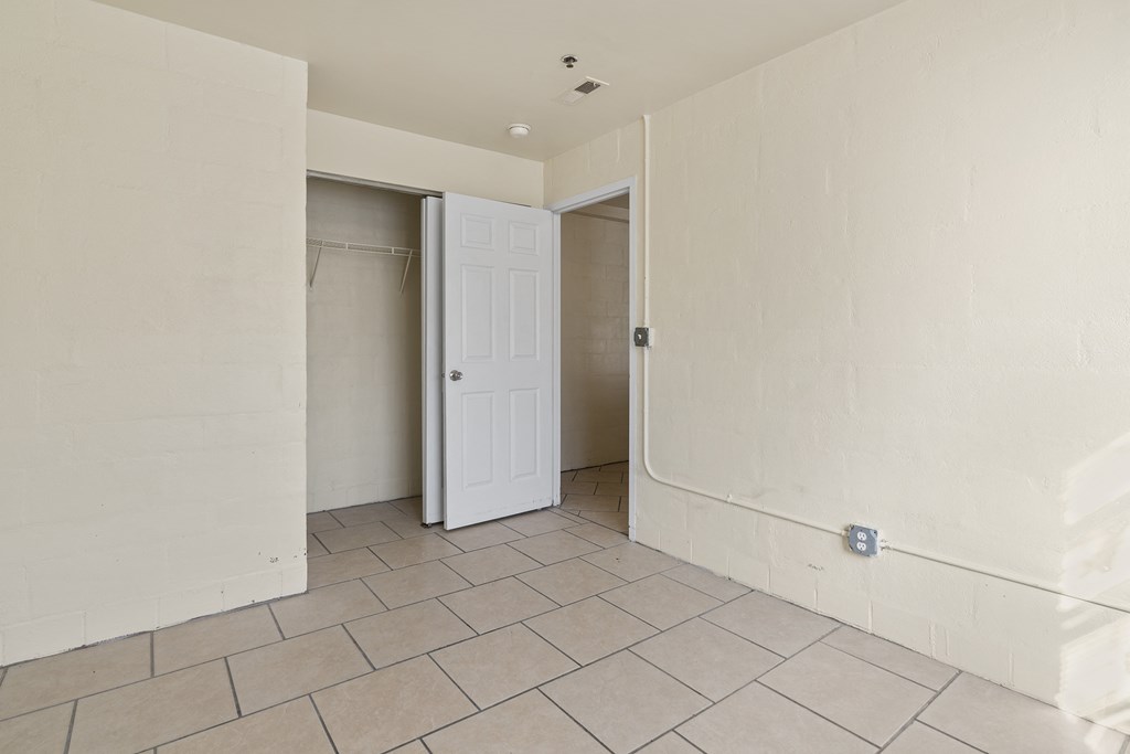 the living room has a door to the closet and a tiled floor