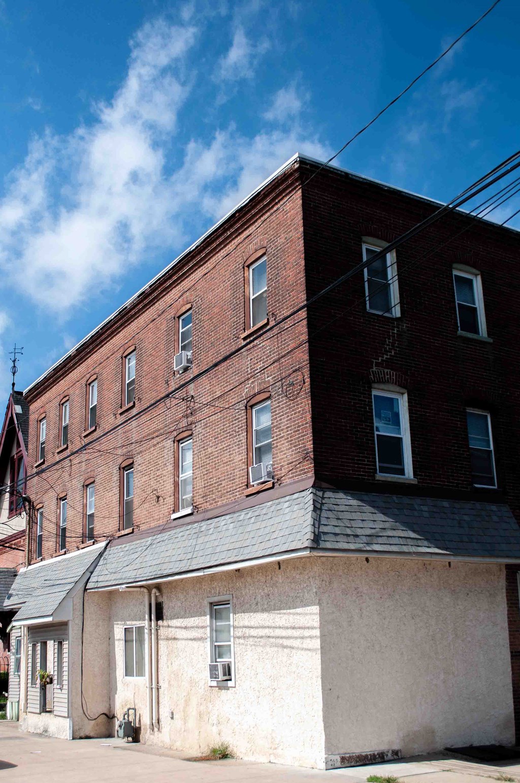 an old brick building on a street with a blue sky