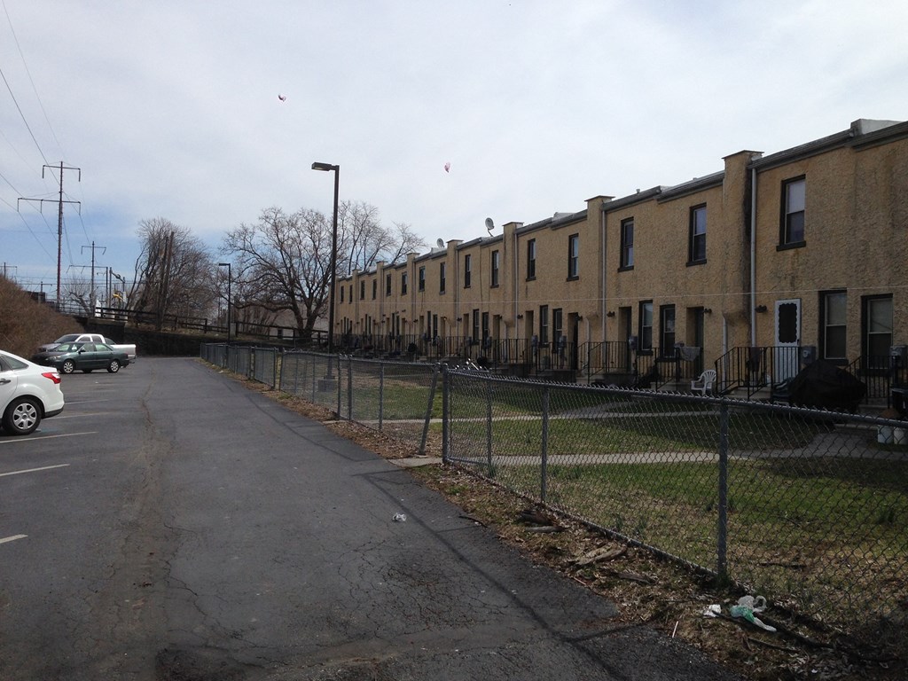 a row of apartment buildings on a city street with a fence