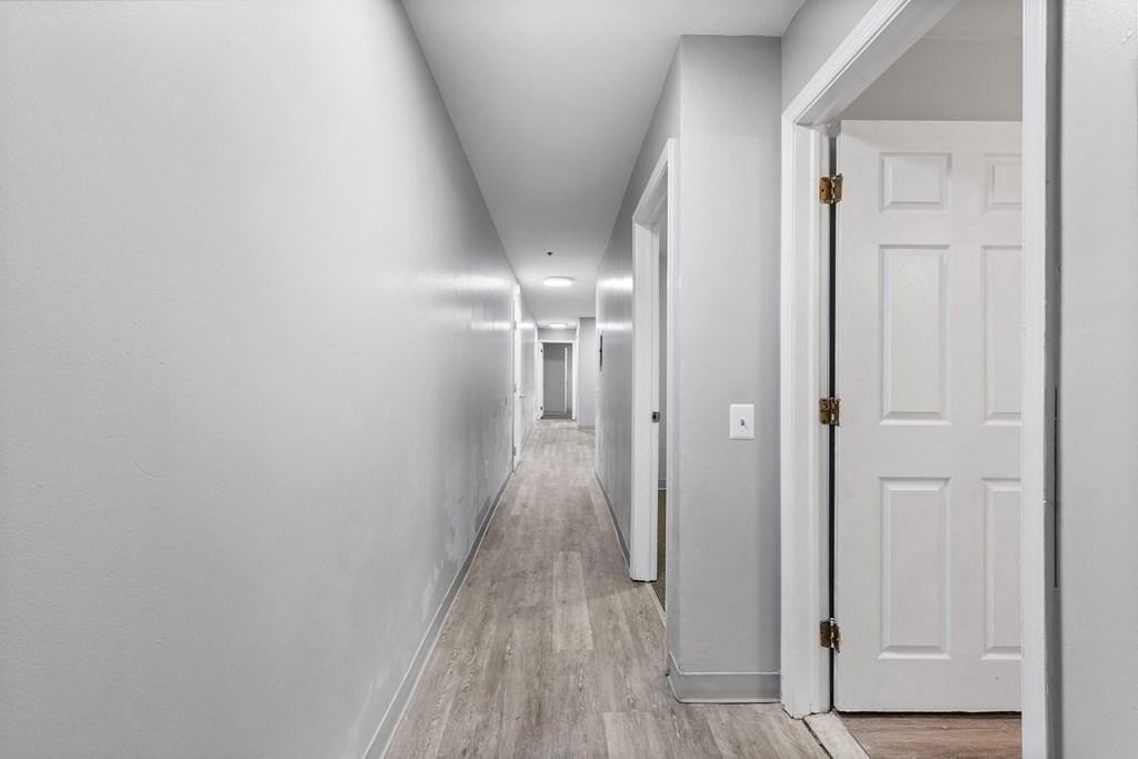 a hallway with white walls and a white door