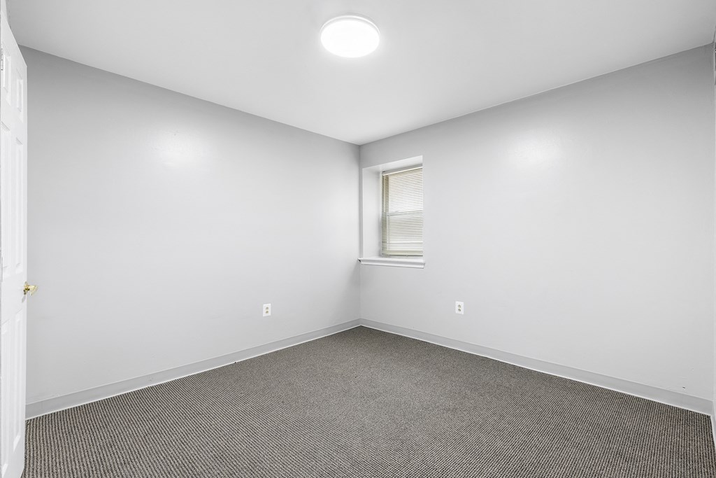an empty room with carpet and a window