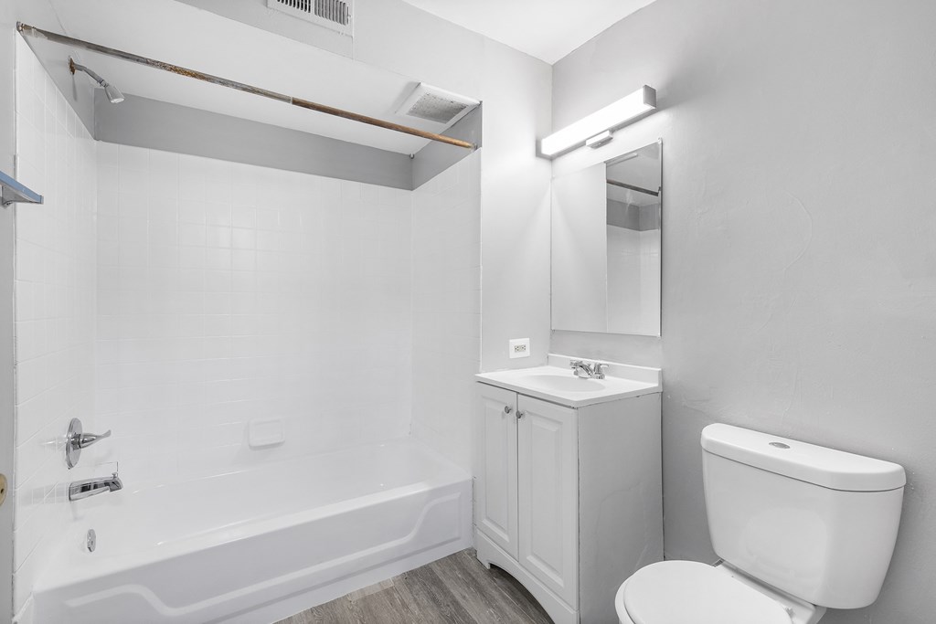 a bathroom with a toilet and a tub and a sink