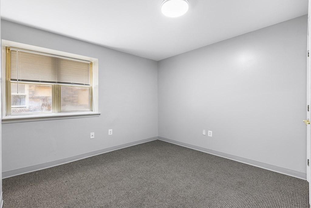 an empty room with white walls and a window