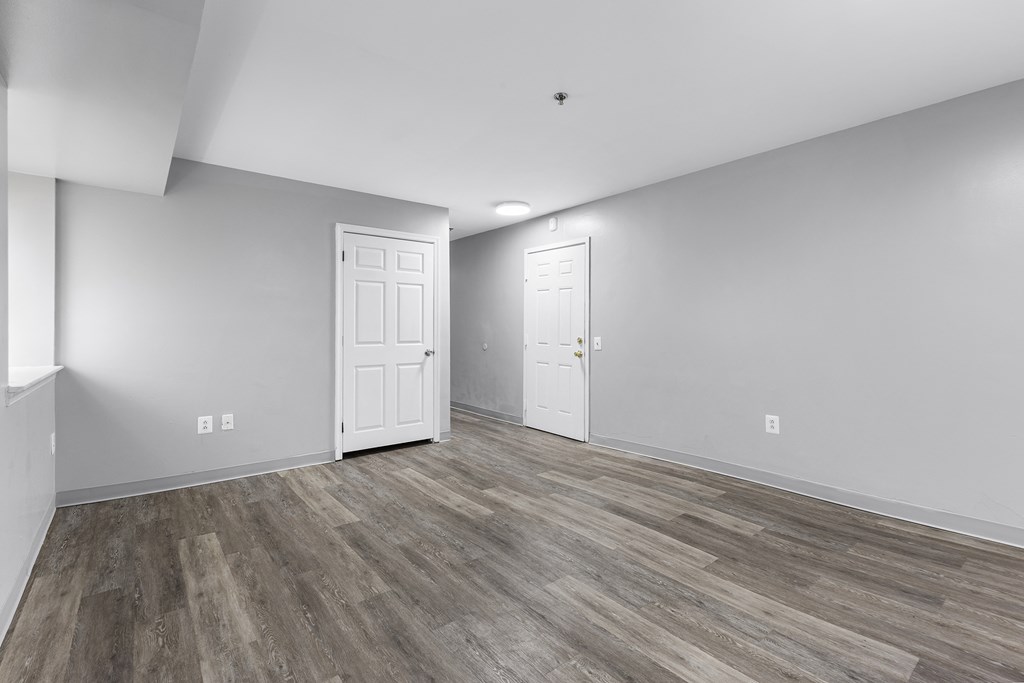 the living room of a new home with white walls and wood flooring