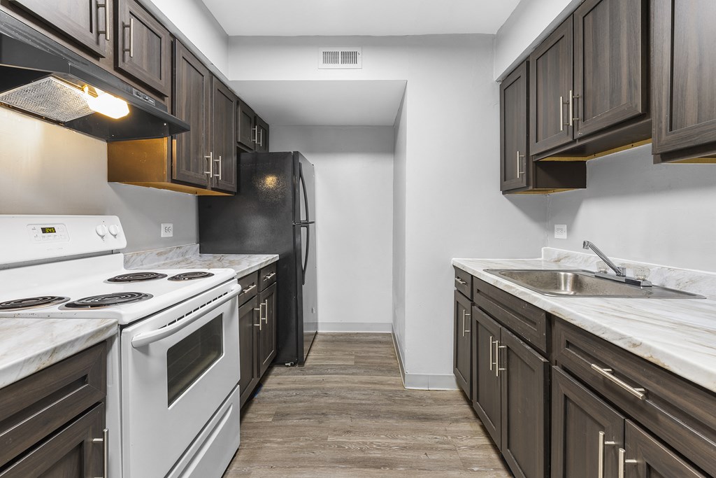 a kitchen with white appliances and dark wood cabinets