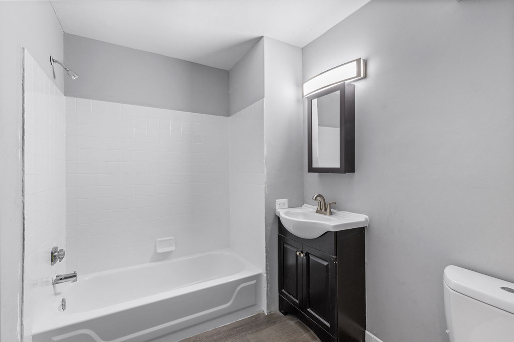 an empty bathroom with a sink toilet and tub