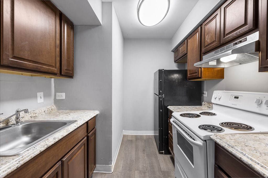 the kitchen of a rental house with a stove refrigerator and sink