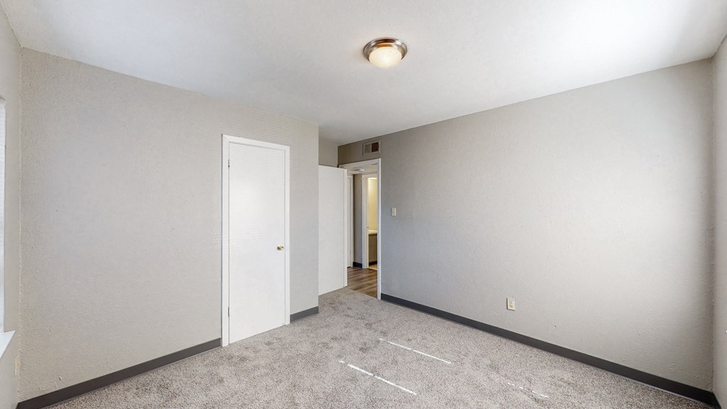 an empty room with white walls and a door to a hallway