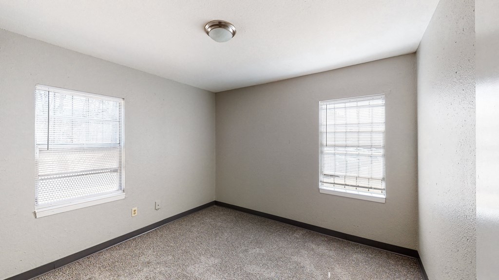 the living room of an empty house with two windows