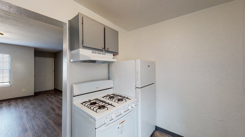an empty kitchen with a stove and a refrigerator