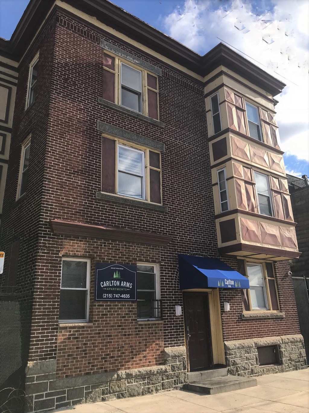 a red brick building with a blue awning
