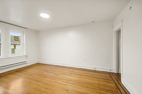 A room with wooden floors and white walls.