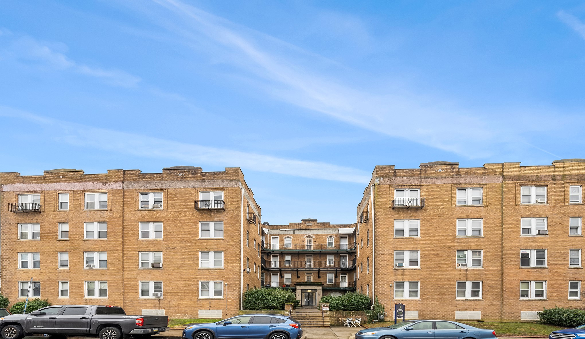A large brick building with a parking lot in front.