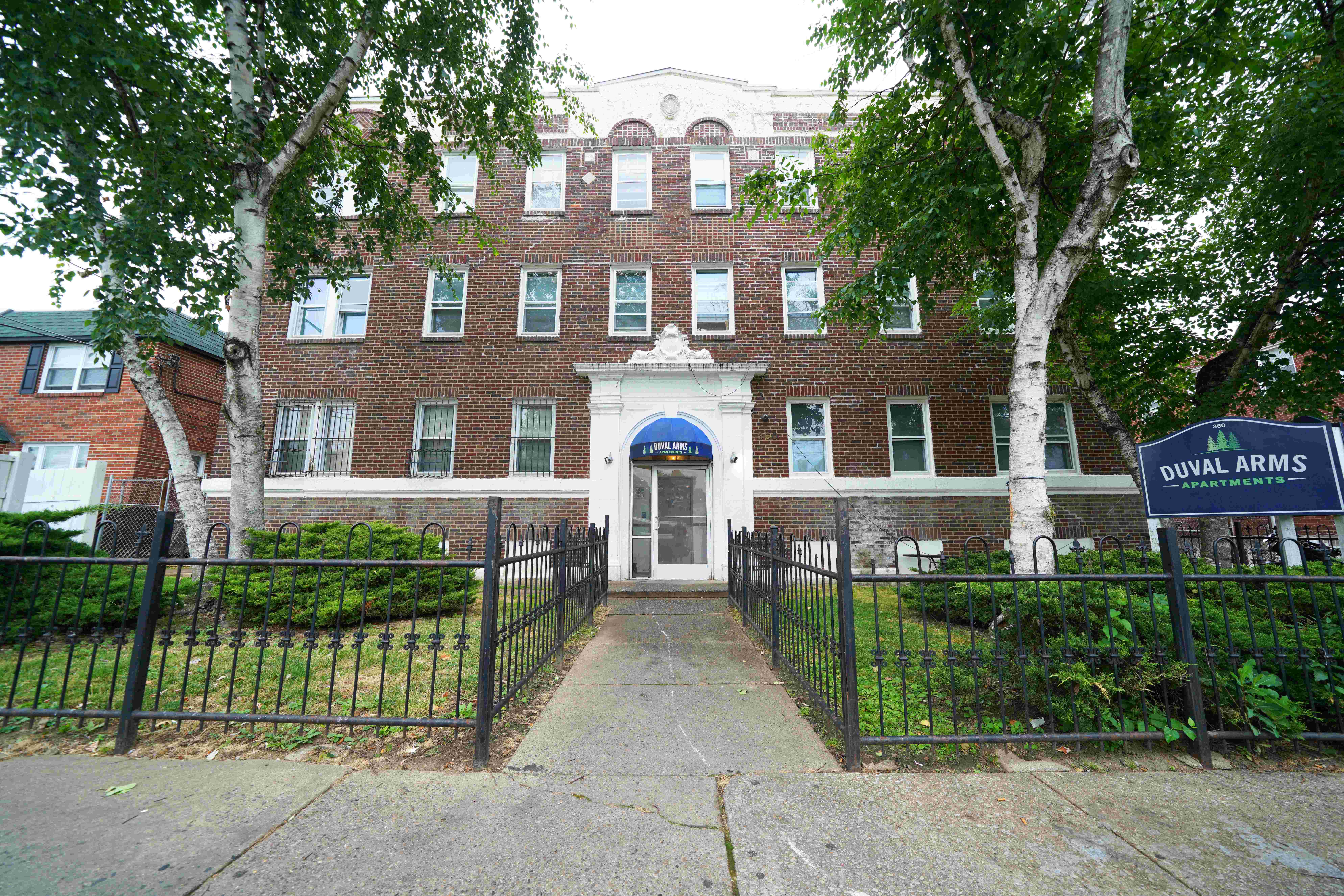 a large brick building with a wrought iron fence in front of it