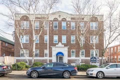 A brick building with a white entrance and a sign that says "The Plaza."