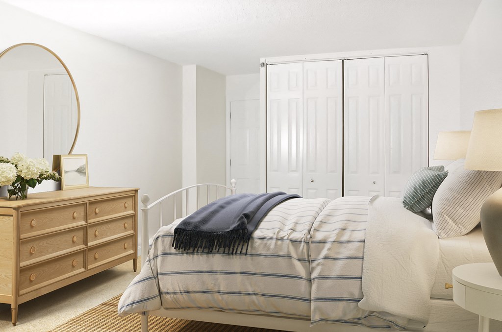 a bedroom with a bed and a dresser with a mirror