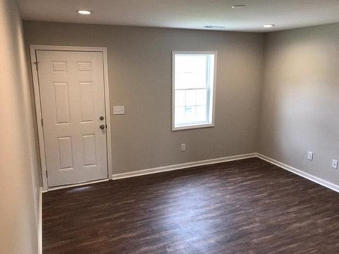 a empty room with a white door and a window