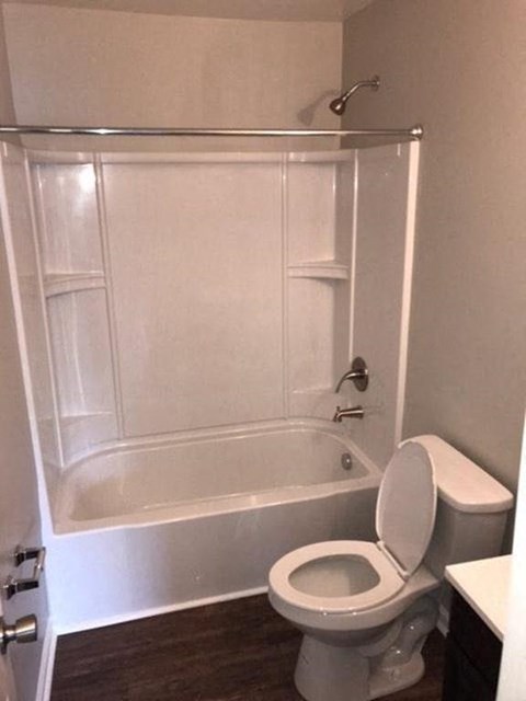 a white bathroom with a toilet and a shower