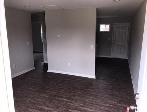 an empty living room with white walls and wood floors