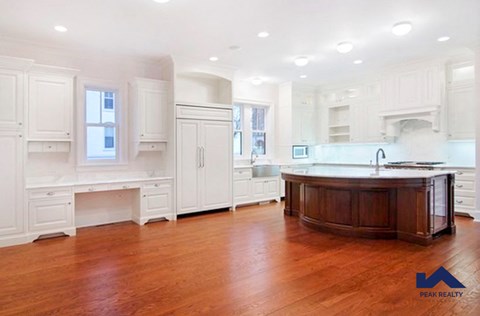 a large kitchen with white cabinets and a wood floor