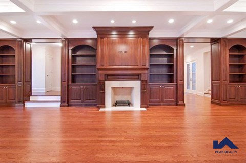 a large living room with a fireplace and wooden furniture