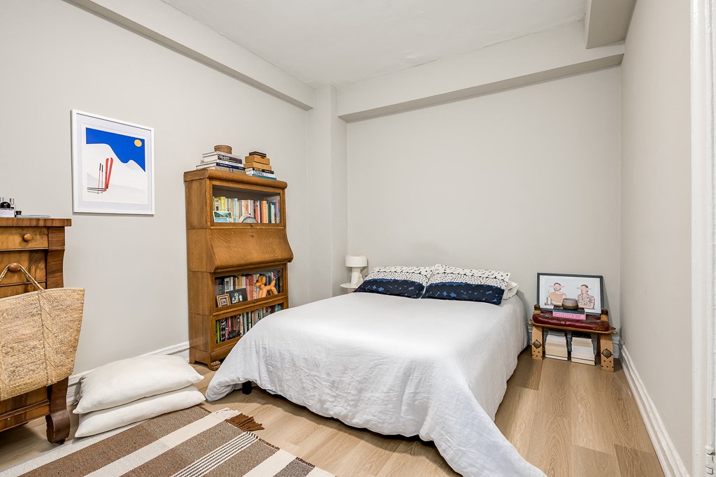 a bedroom with a large bed and a bookshelf