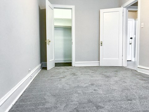 an empty room with white doors and a carpeted floor