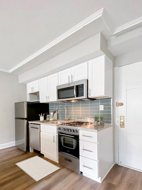 a kitchen with white cabinets and a stove and a microwave