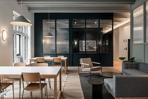 A modern dining room with a long table and chairs.