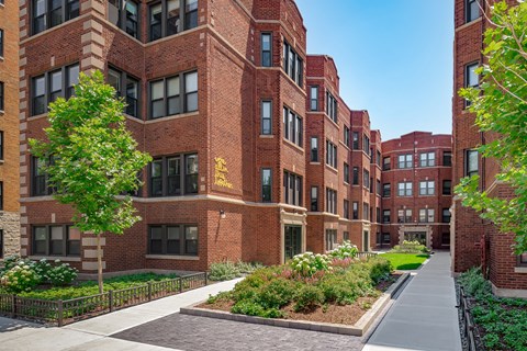 a sidewalk in front of a large brick building