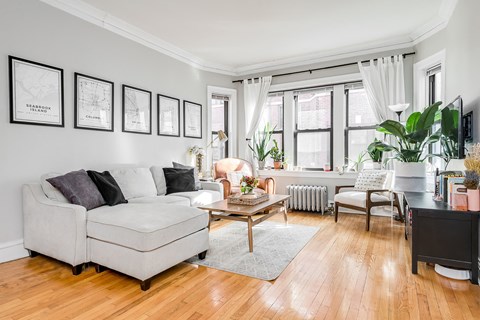 a living room with white furniture and a large window