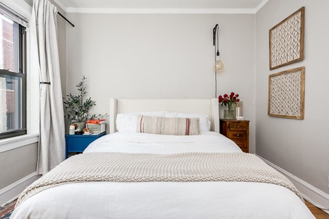 a bedroom with a white bed and a window