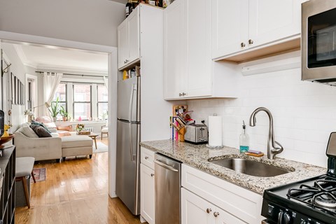 a kitchen with white cabinets and granite counter tops and a sink
