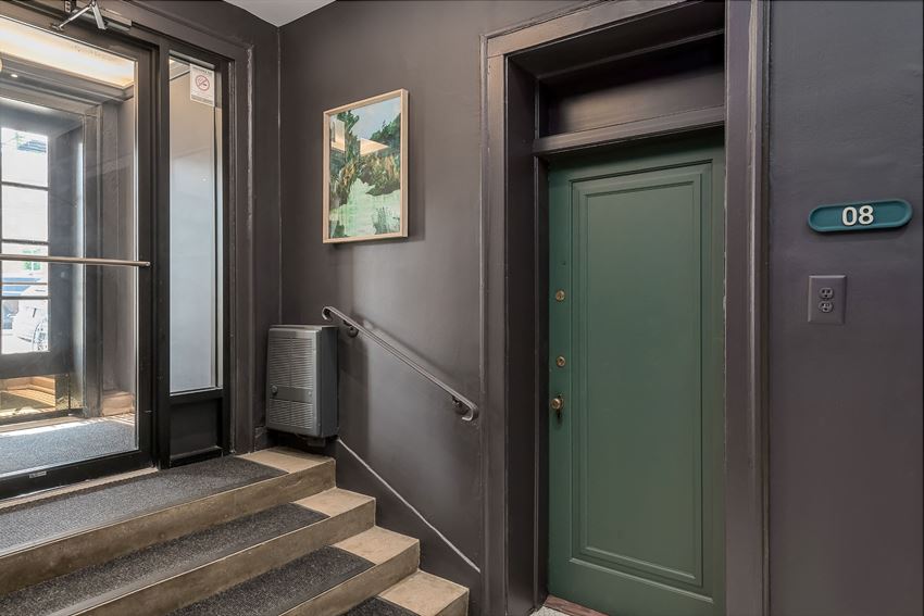 the entrance to a building with stairs and a green door