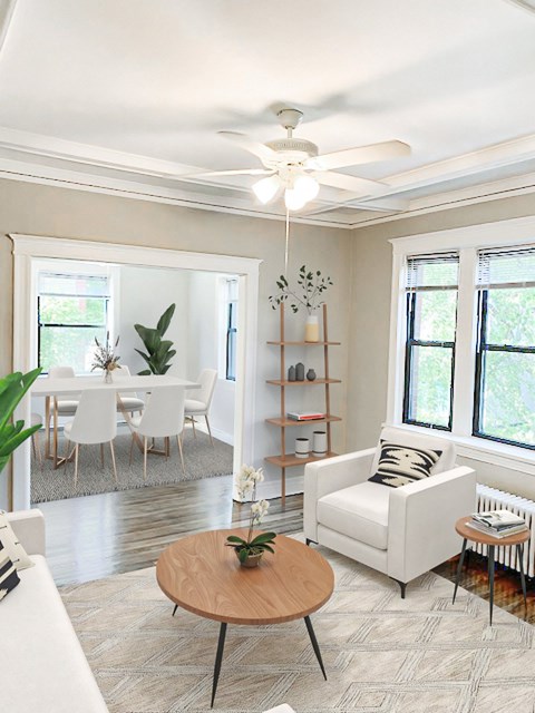 A living room with a white couch, a wooden coffee table, and a ceiling fan.