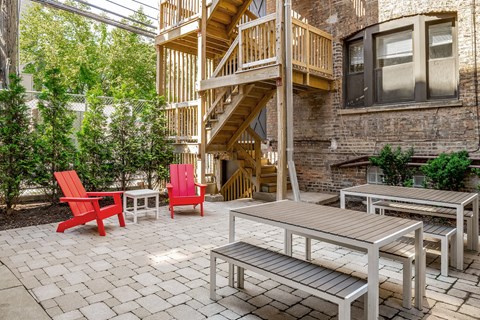 a patio with tables and chairs and a staircase