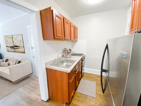 A kitchen with wooden cabinets and a stainless steel refrigerator.